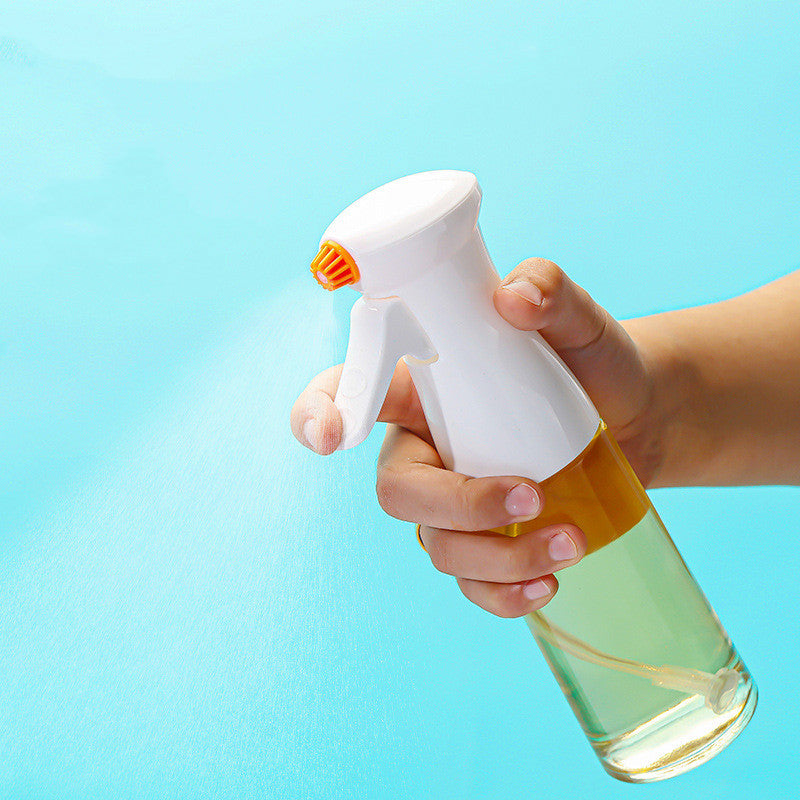 Hand holding a spray bottle with a clear liquid against a light blue background