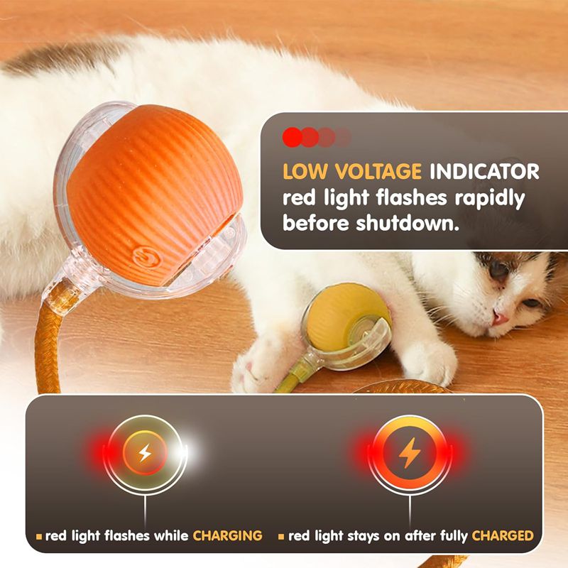 Cat playing with an orange and yellow toy with charging indicators on a wooden surface.
