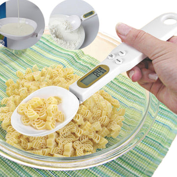 Digital kitchen scale measuring pasta with a hand holding it, on a green and white striped surface.